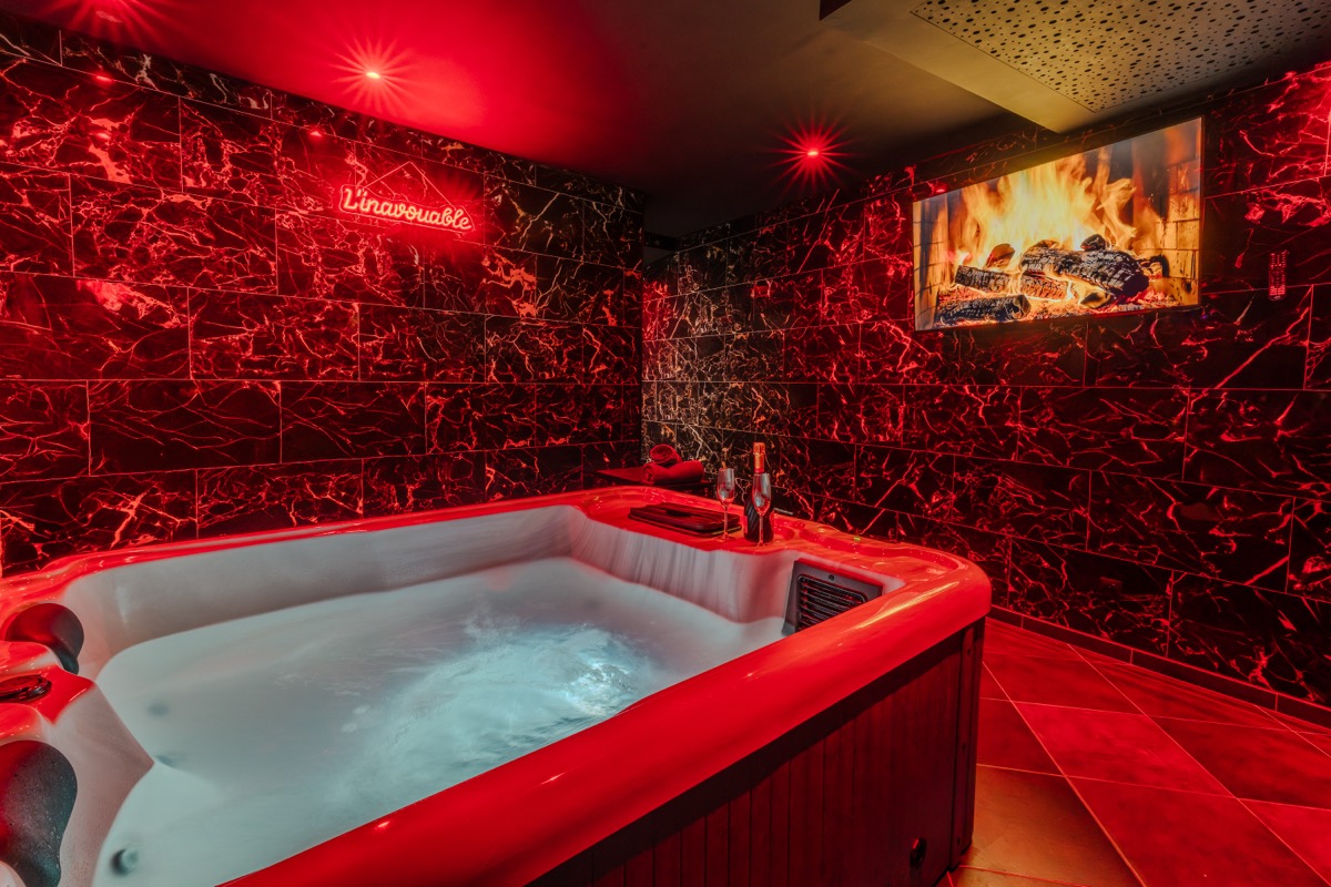 Jacuzzi privatif en ambiance rouge tamisée — L'Inavouable, Côte d'Opale