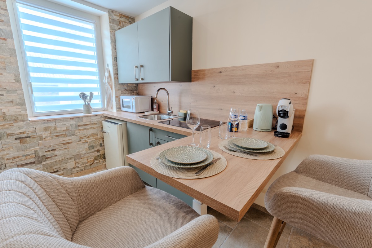 Kitchenette équipée et coin repas pour deux — love room L'Inavouable à Marquise