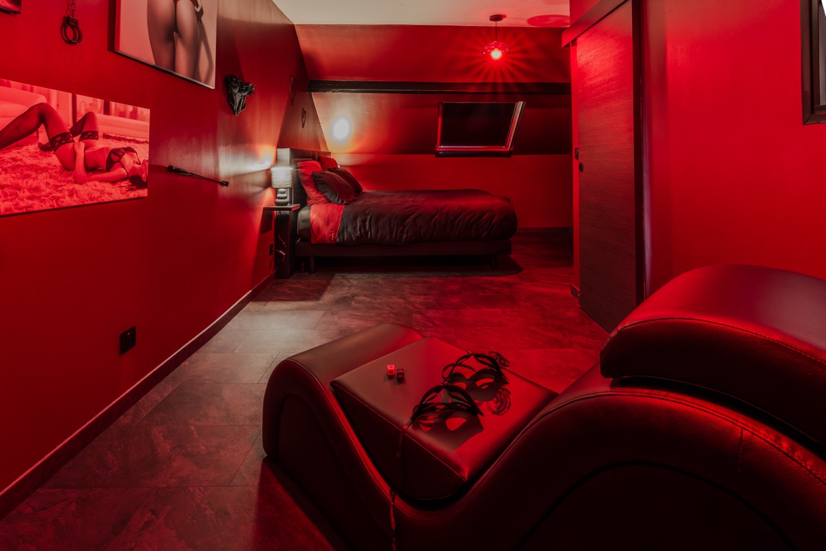 Fauteuil tantra et espace détente de la Red Room — L'Inavouable, Côte d'Opale