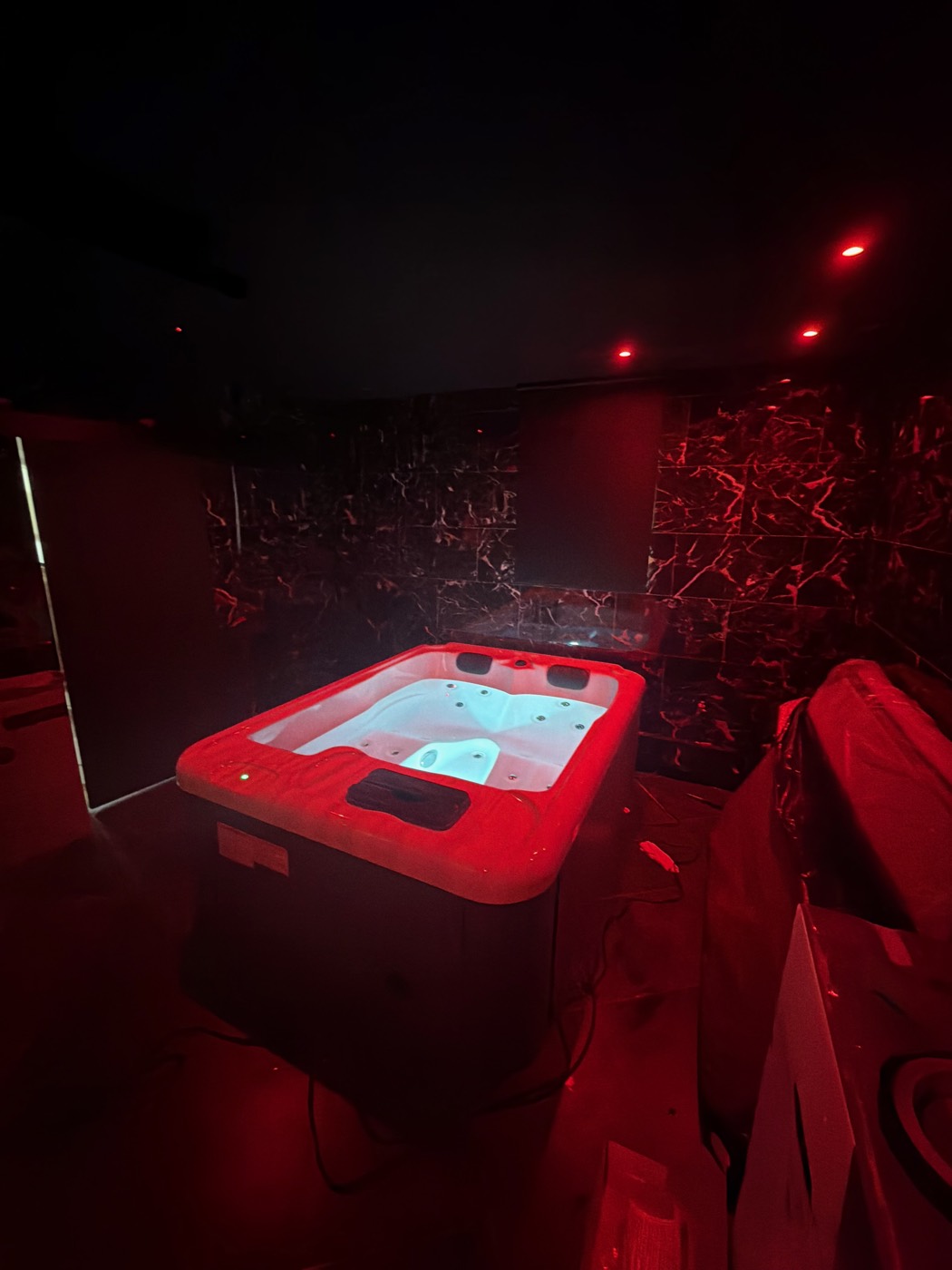 Jacuzzi privatif de la love room L'Inavouable, ambiance tamisée, à Marquise