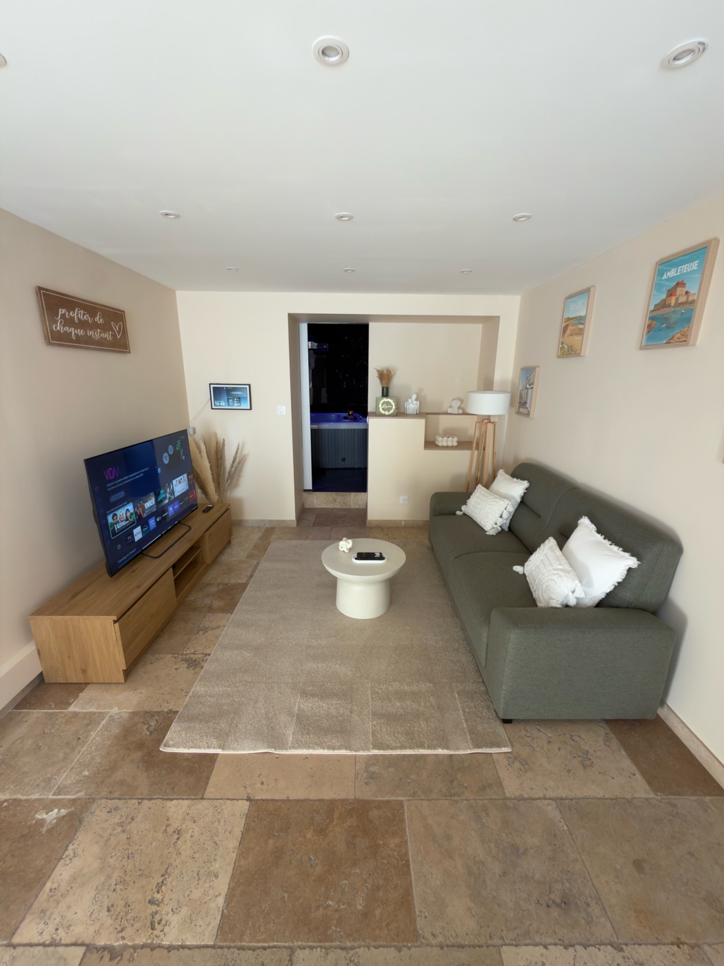 Pièce de vie cosy avec canapé et écran — love room L'Inavouable, Marquise