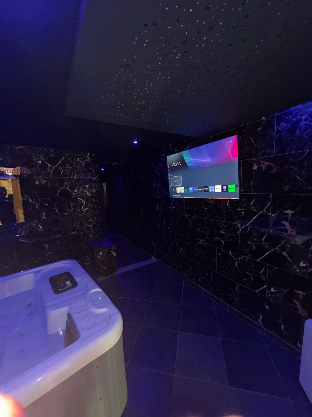 Jacuzzi privatif en ambiance tamisée avec téléviseur — love room L'Inavouable, Marquise